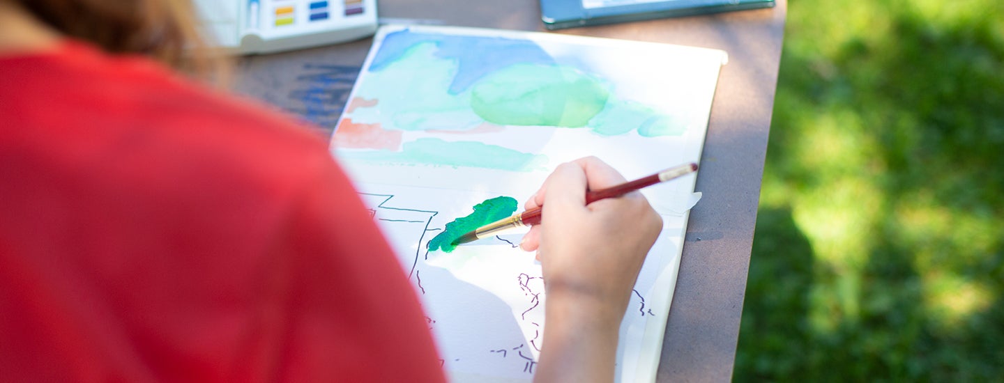 Craft Center member painting with water colors.